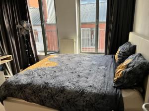 a bedroom with a bed and a large window at center appartement 2 rooms in Alphen aan den Rijn