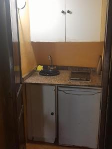 uma pequena cozinha com um lavatório e um fogão em Navila René em Cidade de Ibiza