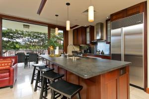 a kitchen with a counter and some chairs in it at Ko Olina Beach Villas B304 - 3BR Luxury Condo with Stunning Ocean View & 2 Free Parking in Kapolei