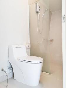 a white bathroom with a shower and a toilet at 153 Mountain View in Ban Huai Phai
