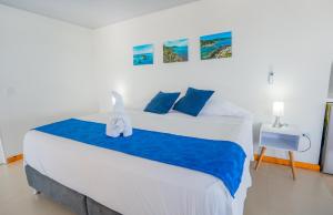 a bedroom with a large white bed with blue sheets at Hotel El Pirata Morgan in Providencia