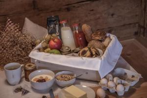 a table topped with a basket of bread and eggs at Ciasa Somuer - Sorà in San Vigilio Di Marebbe
