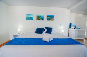 Un dormitorio con una cama grande con un cisne. en Hotel El Pirata Morgan, en Providencia