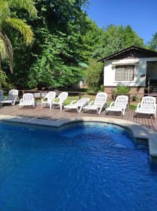 un groupe de chaises blanches assises à côté d'une piscine dans l'établissement Alpenhaus Bier und Gasthaus, à Tigre