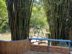 een bamboehek met een blauwe rail voor een bamboeboom bij Sana - Aluguel Econômico in Sana