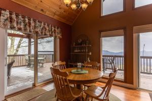 a dining room with a table and chairs and windows at Grand Panorama in Banner Elk