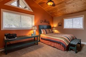 a bedroom with a bed and a desk and windows at Grand Panorama in Banner Elk