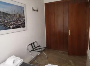 1 dormitorio con silla junto a un armario en Picasso Suites 3.2 Paseo de Gracia, en Barcelona