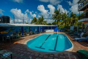 a swimming pool at a resort with chairs and palm trees at Hotel El Pirata Morgan in Providencia +95 photos