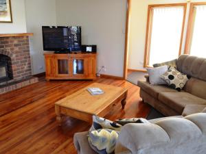a living room with a couch and a television at Freycinet Sands in Coles Bay