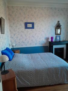 1 dormitorio con 1 cama con edredón azul y blanco en chambre d'hôtes de Flo, en Brosses