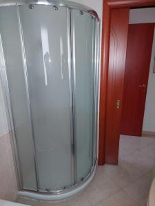 una ducha de cristal en una habitación con puerta roja en Domus Dejanas Selargius, en Selargius