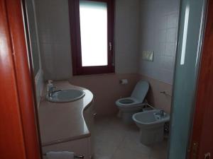 baño con lavabo y aseo y ventana en Domus Dejanas Selargius, en Selargius