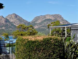 a view of the mountains from a house with a hedge at Freycinet Sands in Coles Bay