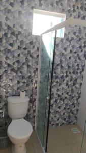 カモシンにあるCasa de temporada Camocimのバスルーム(トイレ、ガラス張りのシャワー付)