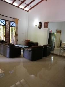 uma sala de estar com sofás de couro num quarto em The Madampa Village Side Lodge em Ambalangoda