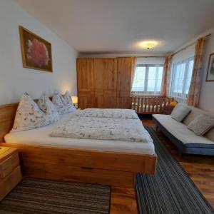 a bedroom with a large bed and a couch at Veitnhof Vomperberg in Vomp