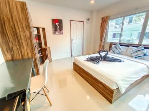 a bedroom with a bed with a large window at Sailor Hotel Pattaya in Pattaya South