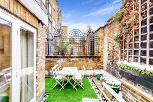 a patio with a table and chairs on a brick building at Park Lane Apartments Marble Arch in London