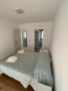 Dormitorio blanco con cama con colcha de rayas en blanco y negro en Moreno Soñado en Tandil