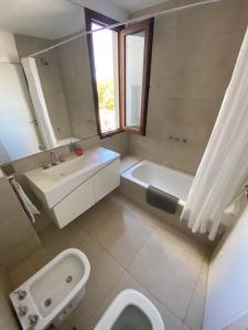 baño con lavabo y aseo y ventana en Moreno Soñado en Tandil