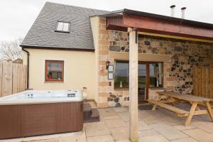 a hot tub in the backyard of a house at 2 Eden at Williamscraig Holiday Cottages in Linlithgow