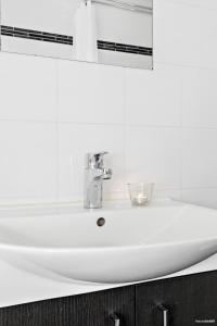 - białą umywalkę w łazience z lustrem w obiekcie First Camp Kolmården-Norrköping w mieście Kolmården