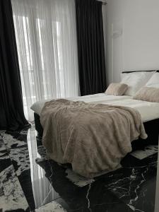 ein Schlafzimmer mit einem Bett und einem großen Fenster in der Unterkunft Apartment by Gustav in Breslau