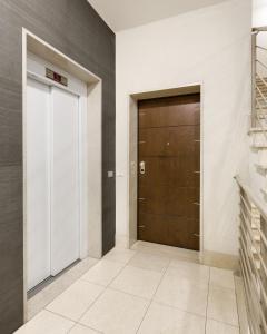 un couloir avec une porte marron et un escalier dans l'établissement Casa Massima Suites, à Casamassima