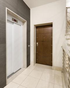 a hallway with a brown door and a staircase at Casa Massima Suites in Casamassima