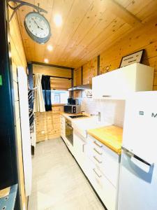 a kitchen with a clock on a wooden ceiling at Studio Du Moulin in Saint-Laurent-dʼAndenay