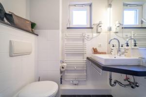 a white bathroom with a sink and a toilet at Auszeit Hotel Hamburg in Hamburg