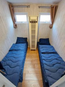 two beds in a small room with two windows at KD 866 - Vakantiepark Kijkduin in The Hague