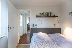 ein Schlafzimmer mit einem Bett und einem Bücherregal an der Wand in der Unterkunft Ferienwohnung Merle in Wyk auf Föhr