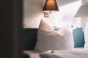 a bed with a white pillow and a lamp at Auszeit Hotel Hamburg in Hamburg