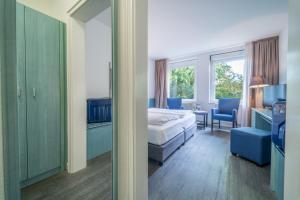 ハンブルクにあるAuszeit Hotel Hamburgのベッドルーム1室(ベッド1台付)、デスクが備わるベッドルーム1室が備わります。