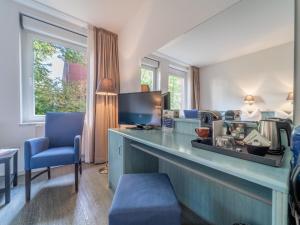 a living room with a counter and blue chairs at Auszeit Hotel Hamburg in Hamburg