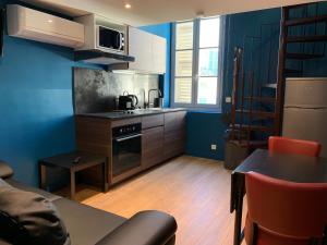 d'une cuisine avec des murs bleus, une table et une cuisinière. dans l'établissement Appartements Nice Centre Carré d’or, à Nice