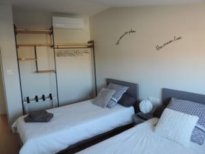 1 Schlafzimmer mit 2 Betten und einem Schrank in der Unterkunft Agréable maison de village avec garage & terrasse in Lespignan