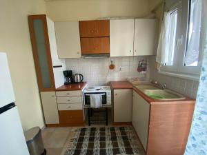 a small kitchen with a sink and a stove at Feel Home in Volos +1 photo