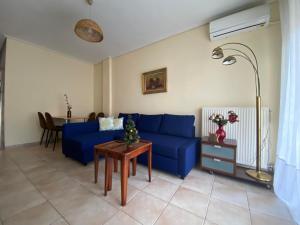 a living room with a blue couch and a table at Feel Home in Volos
