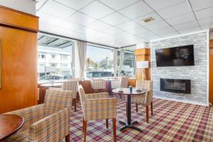 a living room with a fireplace and a table and chairs at Barrowfield Hotel in Newquay