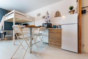 a kitchen with a refrigerator and a table and chairs at L'Ostalet in Saint-Lary-Soulan