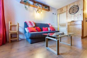 a living room with a blue couch and a glass table at La Fusta in Saint-Lary-Soulan