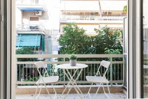 een tafel en 2 stoelen op een balkon bij Groovy 2BR Apartment in Koukaki by UPSTREET in Athene