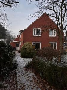 Ferienhaus Lotte في Detern: منزل من الطوب الأحمر مع ثلج على الأرض