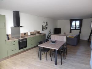 eine Küche und ein Esszimmer mit einem Tisch und Stühlen in der Unterkunft Agréable maison de village avec garage & terrasse in Lespignan