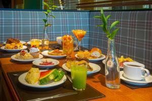 una mesa cubierta con platos de comida y bebida en Hotel Laghetto Vivace, en Canela