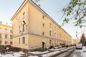 a large yellow building on a snowy street at Elektoralna 19 by Homeprime in Warsaw