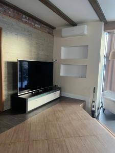 a living room with a flat screen tv on a wall at Boutique Guest House in Liepāja